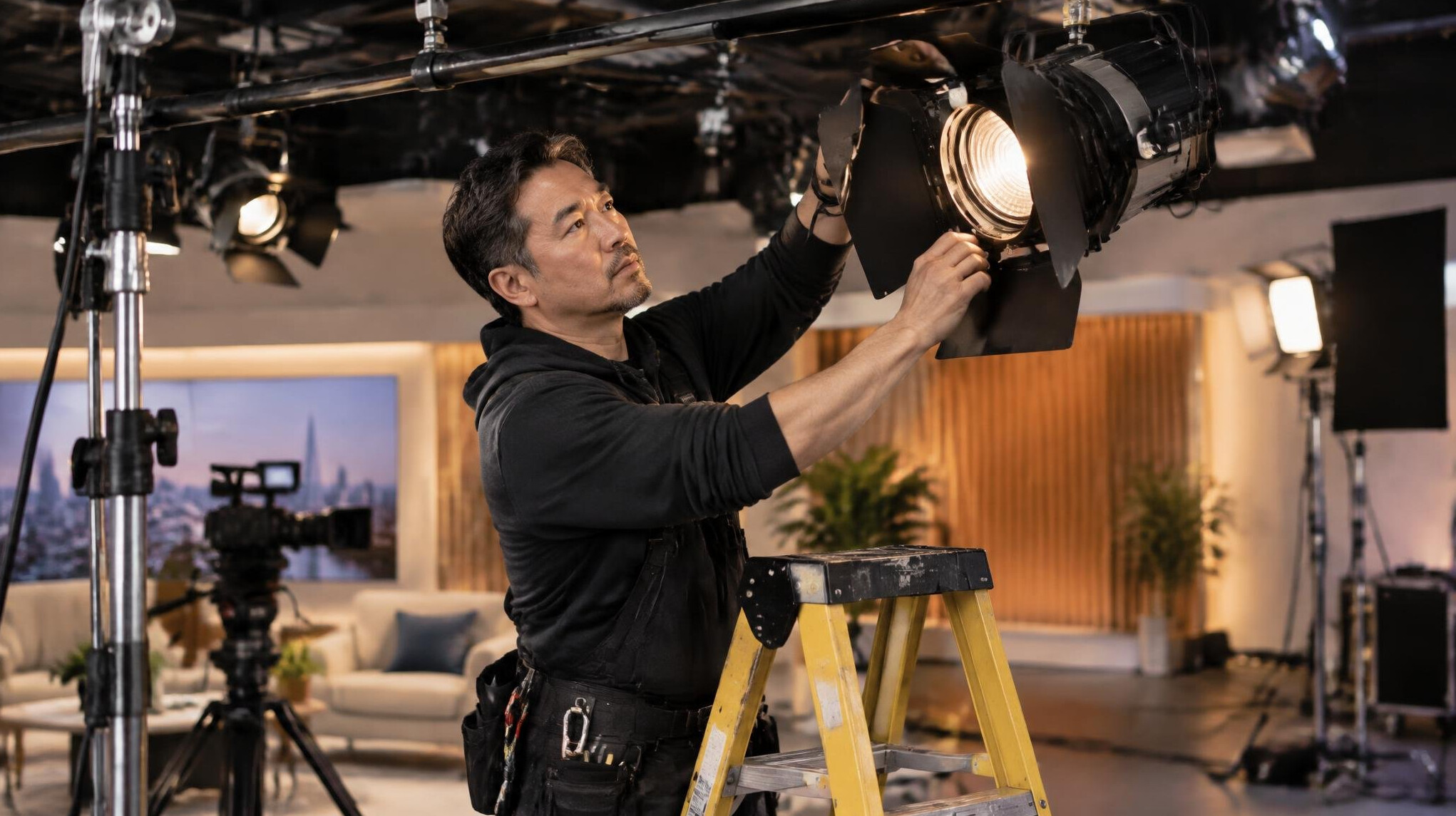 Technician adjusting a studio lighting rig